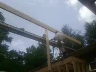 Carpenter setting a ridge beam over a new addition frame — Ice Dam Removal by Roofing Brothers in North Lawrence