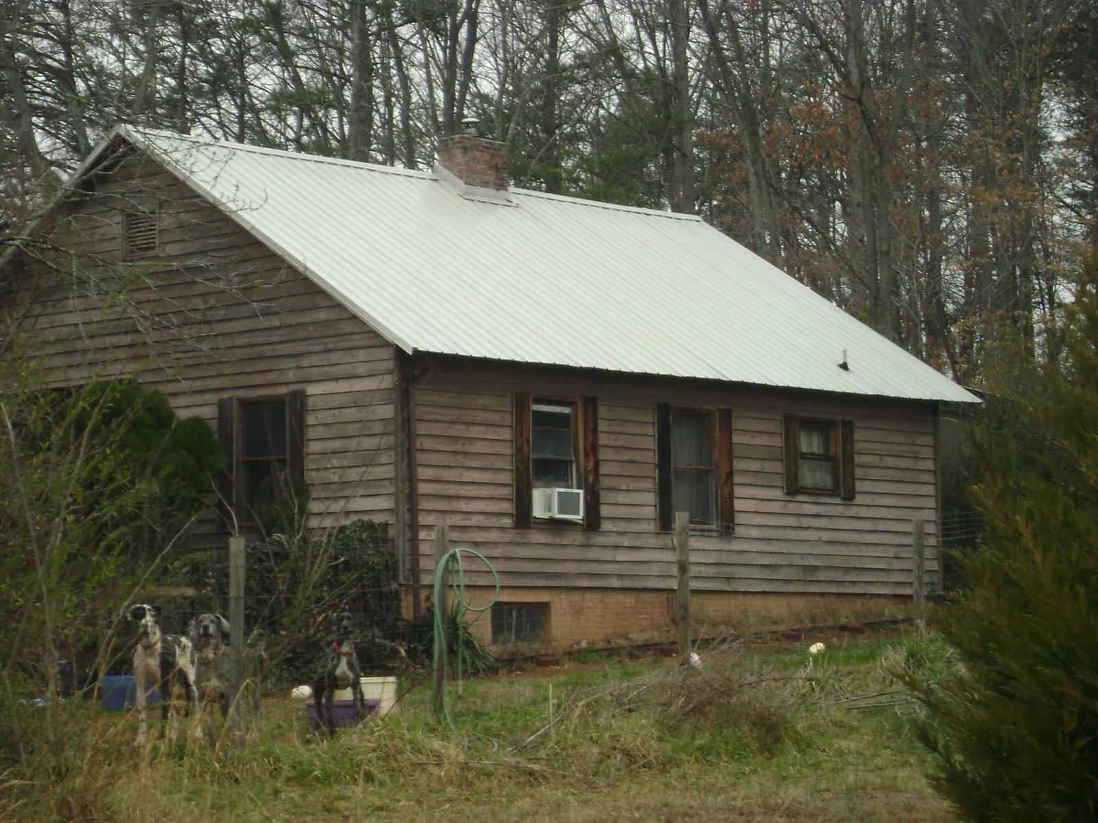 White metal roof on an old wood sided farmhouse, from a Metal Roof Installation job in North Lawrence